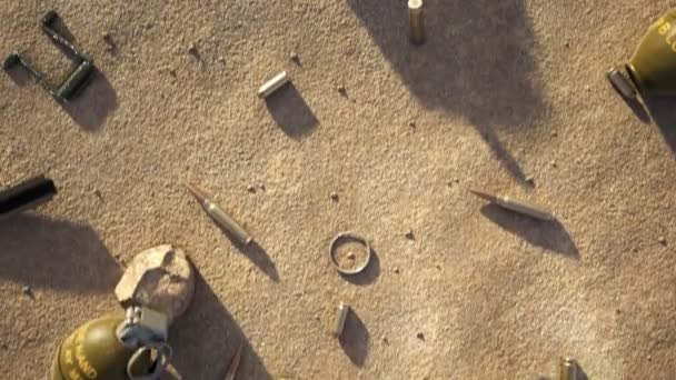 バトルグラウンドビュー カメラは軍用機材の残骸の上を飛行している 異なる手榴弾 その他の物体がある 晴れた日 サンド ストーンズ 戦争は終わった — ストック動画