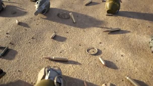 战场上的风景 照相机正在飞越剩余的军事装备 这里有不同的手榴弹 子弹弹壳 硬币和其他物体 阳光灿烂的日子 战争结束了 — 图库视频影像