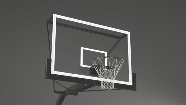 バスケットボールコートで見る カメラはリムでボードに焦点を当てて回転する 煙とほこり ゴールを決めてポイントを獲得 バスケットをしよう 競争準備について スラムダンク — ストック動画