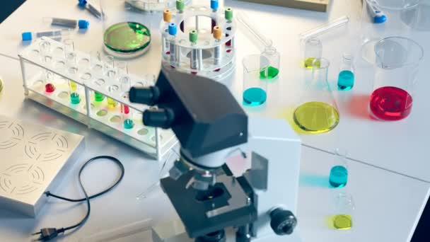 研究室の無限のアニメーション サイドビュー 異なったテスト管 顕微鏡 バーナー ビーカーが付いている決して終わらないテーブル 血液サンプルと液体分析 ラボインテリア スターリル グラスウェア — ストック動画