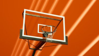 Turuncu bir spor salonunda basketbol potası. Çevreleyen renkli dinamik soyut. Çok popüler bir takım sporunun sembolü. Yasal bir kariyer seçimi. Genç sporcular rüya görür. Kamera yönü.