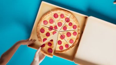 Öğle yemeği saatinde pizza kutusunun açılışının havadan görüntüsü. Elleri lezzetli pizza dilimlerini birer birer alıyor. Kamera dönmeye devam ediyor. Arkadaşlarla parti. Lezzetli fast food atıştırmalıkları. Mavi arka plan. 3B Canlandırma