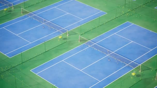 テニスコートのトレーニングの巨大な複合体 バードの視点 あなたのスキルを鍛え より良いプレーヤーになる 青と緑の表面 イエローボール 各裁判所は網の塀によって分けられます Hdについて — ストック動画