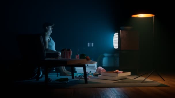 Товстий Хлопець Сидить Темній Кімнаті Дивлячись Телевізор Оточений Тонами Фаст — стокове відео