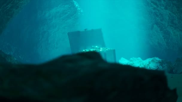 一个神秘的海底洞穴中的海底秘密宝藏一个开着的旧木箱装满了珠宝 硬币和黄金 阳光照射着它们 在蓝水里的海盗胸膛 — 图库视频影像