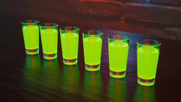 バーのガーリッシュグリーンショットのアニメーション ナイトクラブのテーブルの上のカラフルなアルコール飲料 パーティータイム 祝福する バックグラウンドで明るく輝くネオン カクテルクラブのナイトライト — ストック動画