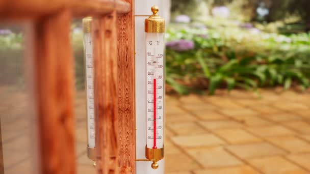 庭の屋外温度計が木窓に取り付けられています ケルシウスの気温を示す水銀のコラムは華氏スケールである ウィーターの測定 晴れた日 夏か春か — ストック動画