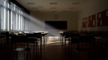 Işık ışınları boş karanlık sınıfa düşüyor. Kamera sıra sıra sandalye ve masaların yanından geçiyor. Teneffüste öğrencilerin olmadığı bir ders. Terk edilmiş okul. Rahatsız edici ruh hali..