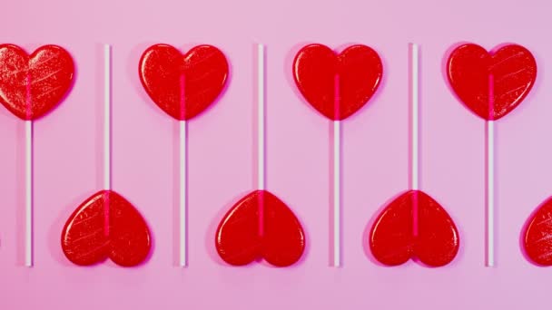 无缝线动画的红色心形棒棒糖 一套用木棍做的甜甜食 爱情的象征 粉色背景的甜糖果 甜蜜浪漫的情人节礼物 — 图库视频影像