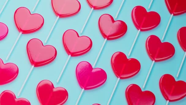 无缝线动画的红色心形棒棒糖 一套用木棍做的甜甜食 爱情的象征 蓝色背景的甜糖果 甜蜜浪漫的情人节礼物 — 图库视频影像
