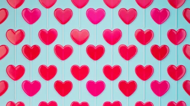 无缝线动画的红色心形棒棒糖 一套用木棍做的甜甜食 爱情的象征 蓝色背景的甜糖果 甜蜜浪漫的情人节礼物 — 图库视频影像