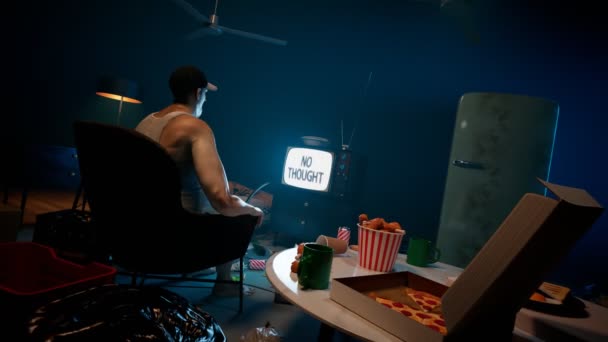 Товстий Хлопець Сидить Темній Кімнаті Дивлячись Телевізор Оточений Тонами Їжі — стокове відео