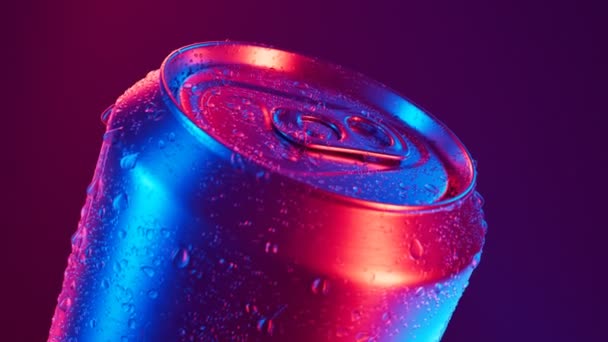 コールドソーダの良い缶 リフレッシュドリンク カメラはドロップレットを流れています 冷たい缶詰にされた飲み物は その上に水滴を飲む 喉の渇きを癒す準備ができました 美しい青と紫色のライト リフレッシュ — ストック動画