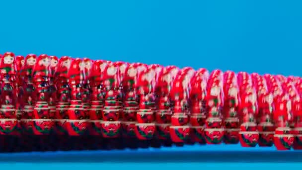 蓝色背景的漂亮手工制作的Matryoshka娃娃 大量的Babushkas跳到一起 形成了一个波浪 那一大套可爱的俄罗斯传统木制玩具成排排列 无缝线环路 — 图库视频影像