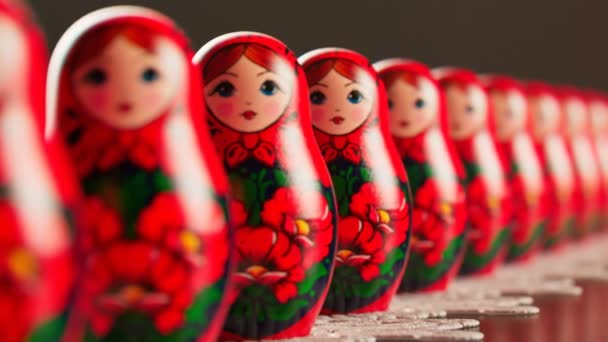 漂亮的手工制作的Matryoshka娃娃连成一排 无数的Babushkas放置在白色的涂鸦上 一套俄罗斯传统木制玩具 用五彩缤纷的装饰品作画的艺术纪念品 — 图库视频影像