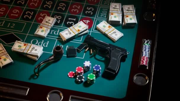 カジノのルーレットテーブルに弾丸 チップが付いている銃 ギャンブル ギャングスター兵器 現金の列の隣に ファスターターが付いたパイプ 危険な遊びという概念 ラスベガスでの犯罪 リスキー エンターテインメント — ストック動画