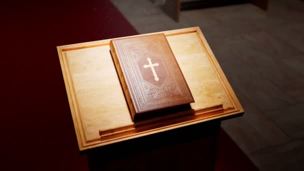 Piękna Biblia Drewnianym Stole Oświetlonym Promieniami Światła Padającymi Ciemnej Kaplicy — Wideo stockowe