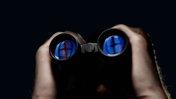 一个男人通过双筒望远镜看 一个戴野外眼镜的人在监视目标间谍技术的概念 间谍装备 观察设备 在监视之下悬念和焦虑的气氛 — 图库视频影像