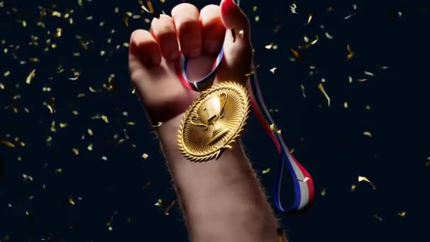 举起一只手拿着闪亮的金牌 冠军和一等奖 冠军的体育奖 赢得了比赛 荣耀的时刻 最伟大的成就Confetti案 — 图库视频影像
