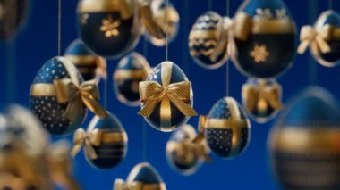 Altın dekoratif kurdeleli Paskalya yumurtaları asılıydı. Bahar kutlaması sırasında güzel renkli yumurtalar. Şirin parlak, altın, parlak yumurtalar. Zarif dekorasyonlar. Mutlu Paskalyalar.