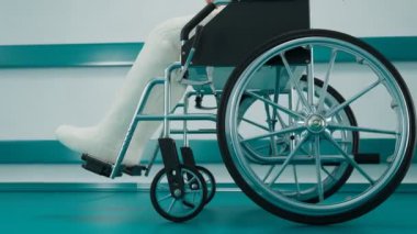 Tekerlekli sandalyede alçılı bacakları olan bir adamın kusursuz döngüsü. Hastanede kırık kemikleri olan bir hasta. Rehabilitasyon sırasında kazadan sonra sakat kalan kişi. Sağlık hizmeti kavramı.