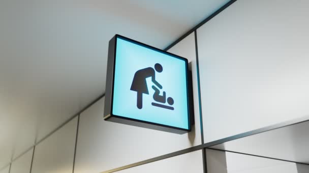 空港のベビーケアルームの入り口の上の青い正方形のサイン 赤ちゃんの世話をする母親のグラフィックシンボル 女性とトッドラーの黒いシルエット 公共の場における情報アイコン — ストック動画