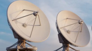 Uydu antenlerinin kusursuz döngüsü. Uzay gözlemevi sinyal araması. Radyo astronomi gözlemevi. Mavi gökyüzünde bir dizi anten silueti. Keşif, bilim, teknoloji.