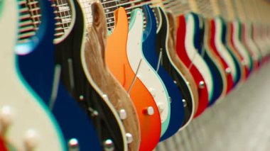 Çeşitli elektro gitarların kusursuz döngü animasyonu. Müzik aletleri dükkanı. Stüdyo ışığıyla müzik aletlerinin zarif çekimi. Rock, heavy metal, blues, pop, rhythm, lead, gitar.