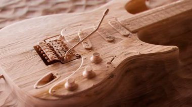 Tahtaya oyulmuş altı telli modern elektro gitarın yavaş çekimleri. Çağdaş müzik aleti. Tahta oyma. Heavy metal, blues, pop, ritim, kurşun. Rock ve hard müzik türü sembolü. Yüksek kazanç sesi.