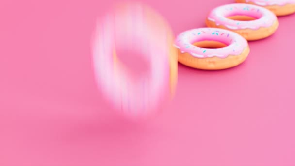 Надувні Кільця Виглядають Пончики Рожевому Фоні Реалістичний Барвистий Гумовий Плавальний — стокове відео
