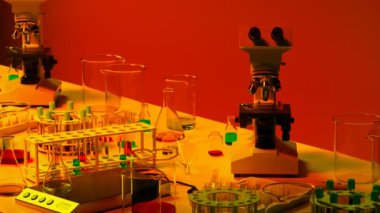 Bilim laboratuarı ekipmanları. Laboratuvar aletleri ve bilimsel aletler sonsuz bir masada. Beher, tüp, mikroskop ve analiz için renkli kimyasallarla kusursuz döngüleme animasyonu.