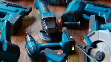 Ahşap arka planda endüstriyel aletler. Elektrikli cihazlar. Zanaatkar atölyesi. Profesyonel elektrikli aletler. Gerekli ekipmanlar. Dairesel testere, kablosuz matkap, çim biçme makinesi, testere, döner çekiç. Döngü