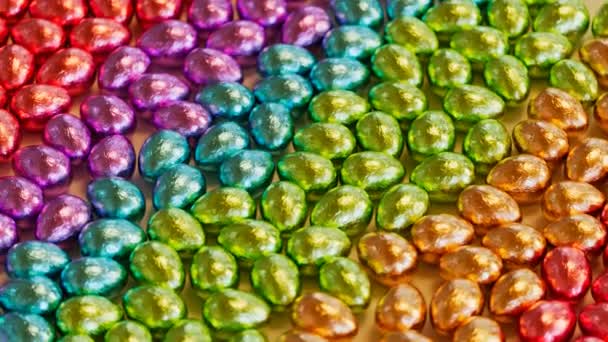 Glänzende Metallische Folie Gewickelte Schokoladeneier Die Einer Mehrfarbigen Regenbogenfarbenen Komposition — Stockvideo