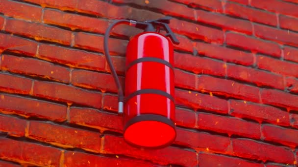 火事の最中に壁に掛かっている赤い消火器 ホットエンジンが上空を飛んでいる 火の暖かい光は下から赤レンガの壁を照らす底から輝きます 危険性について — ストック動画