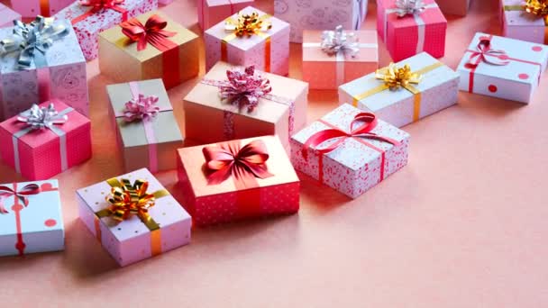 用缎带装饰的盒子 圣诞庆典 周年纪念日 情人节的概念 粉色背景 无限的相机运动 家庭时间 圣诞老人 五彩斑斓的装饰 — 图库视频影像