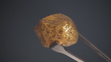 Bir cımbızla tutulan saf altın parçasına yakın plan. Pahalı bir metal parçası. Altın külçe. Altın cevheri, zenginliğin sembolü. Kıymetli hazine. Sermaye, finans ve bankacılık amaçlı yatırım kavramı