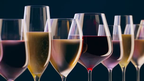 一套玻璃杯 装有不同种类的葡萄酒和在深色背景下闪闪发光的香槟 酒店戏 庆祝新年的概念 周年纪念日 酒精饮料的种类 — 图库视频影像