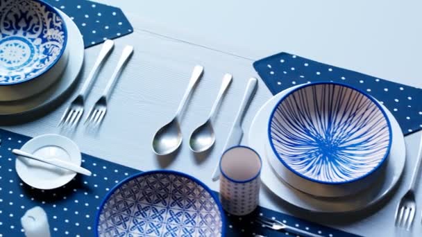 准备参加宴会或婚礼的餐桌 空白手绘传统的白色和蓝色陶瓷餐具 在深蓝色点缀的桌布上有不同的图案 无缝线动画 — 图库视频影像