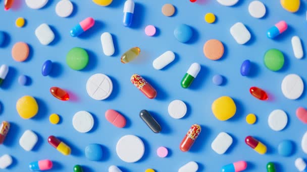 Innumerables Píldoras Multicolores Cápsulas Tabletas Dispersas Suelo Azul Claro Vídeo — Vídeo de stock