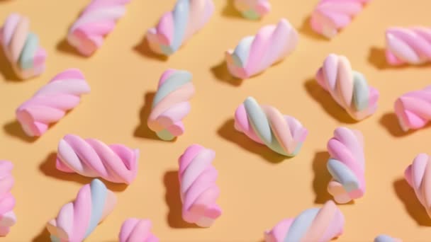 Miękkie Pianki Ułożone Pomarańczowej Powierzchni Dużo Pastelowych Różowych Cukierków Cukrowych — Wideo stockowe