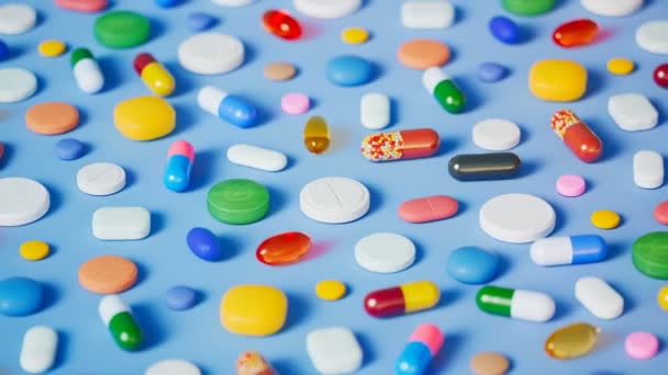 Talloze Veelkleurige Pillen Capsules Tabletten Verspreid Een Lichtblauwe Ondergrond Naadloze — Stockvideo