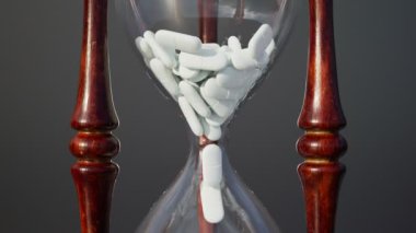Beyaz haplarla dolu bir kum saati ile animasyon. Kapsüller düşüyor. İlaç, eczane ya da sağlık konuları için mükemmel bir geçmiş. Vitamin ve takviye zamanı. Hap almayı unutma..