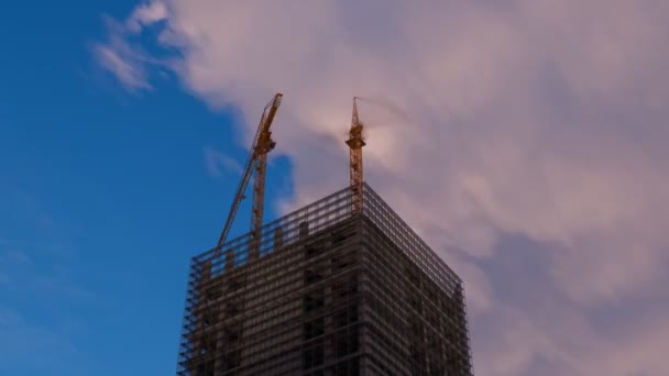 摩天大楼由几台建筑用起重机在一天的时间内建成 美丽的日出云在蓝天背景下快速移动 Scaffolding Assembly Progress Clearly Visible — 图库视频影像