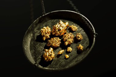Mücevher pulunu altın külçeleriyle kapatın. Altın cevherlerini eski bir pirinç kapta ticaret ya da takas için tartmak. Zenginlik, hazine, servet, başarı, lüks, para kavramı