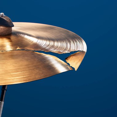 Davullar için bozuk zilin kapanışı. Parlak el yapımı davul plakası hasar görmüş. Davul seti. Profesyonel perküsyon kullanım dışı. Müzik zilinin yan görüntüsü. Klasik müzik enstrümanını mahvetti. Yok Edildi.