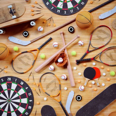 Variety of game equipment. Aerial view on sports gear for baseball, tennis, ping-pong, hokey, darts, skateboarding, basketball. Sports balls, bats and racquets on floor clipart