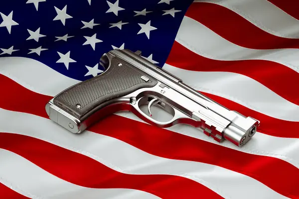 Shiny pistol with the American flag in the background. Silver gun. Homeland security. Armed conflict, war, defend the country. The American flag symbolizes freedom, independence, and strength.