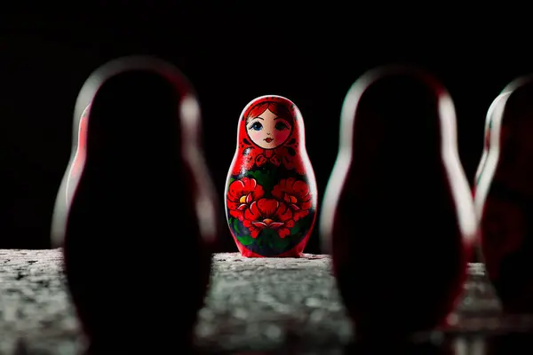 Russian matryoshka dolls crafted by hand are placed in a circle on top of a white folk doily. This art souvenir features intricate ornaments and is perfect for those who love collecting cultural items