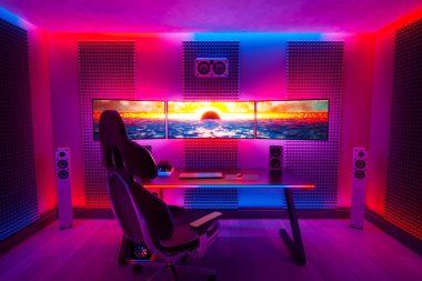 Pembe, mavi ve mor neon ışıklı bir oyun odası olan canlı renkli bir resim. Oyuncular için güçlü bir bilgisayar. Eğlence için rahat modern tasarım odası. Oyun konsepti. Evde iyi eğlenceler..