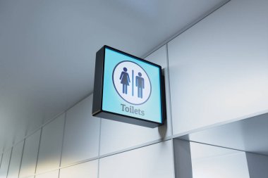 Havalimanı terminalleri, hastaneler, otobüs veya tren istasyonları gibi kamusal alanlardaki tuvaletlerin girişini açıkça gösteren parlak bir tabela. Erkekler ve kadınlar tuvaleti..